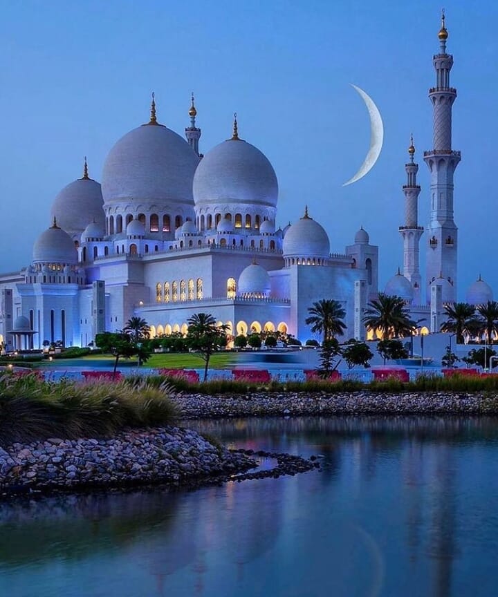 Urlaub, UAE. Die Mondsichel in Abu Dhabi schwebt über der Sheikh Zayed Grand Mosque, einem berühmten Wahrzeichen von Abu Dhabi.